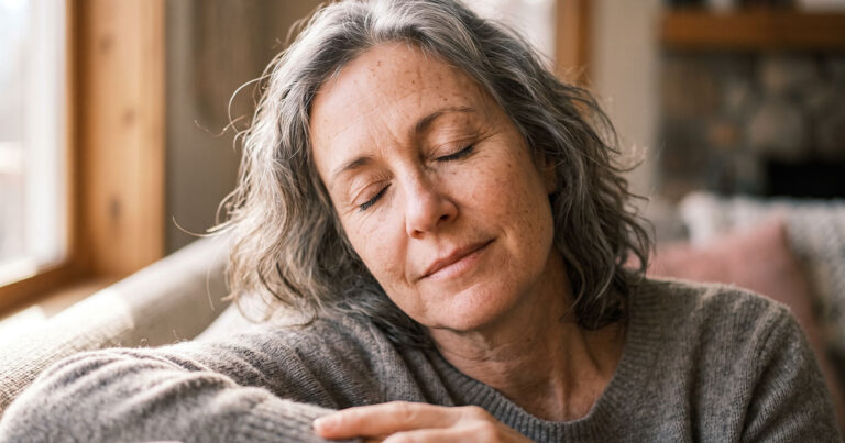 Ältere Frau entspannt mit geschlossenen Augen auf dem Sofa – Ruhe und Erleichterung bei Tinnitus durch die richtige Hörgeräteversorgung